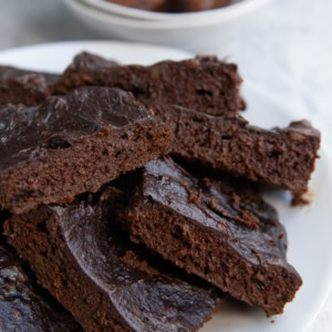 Plate of date brownies with a bowl of dates in the background.