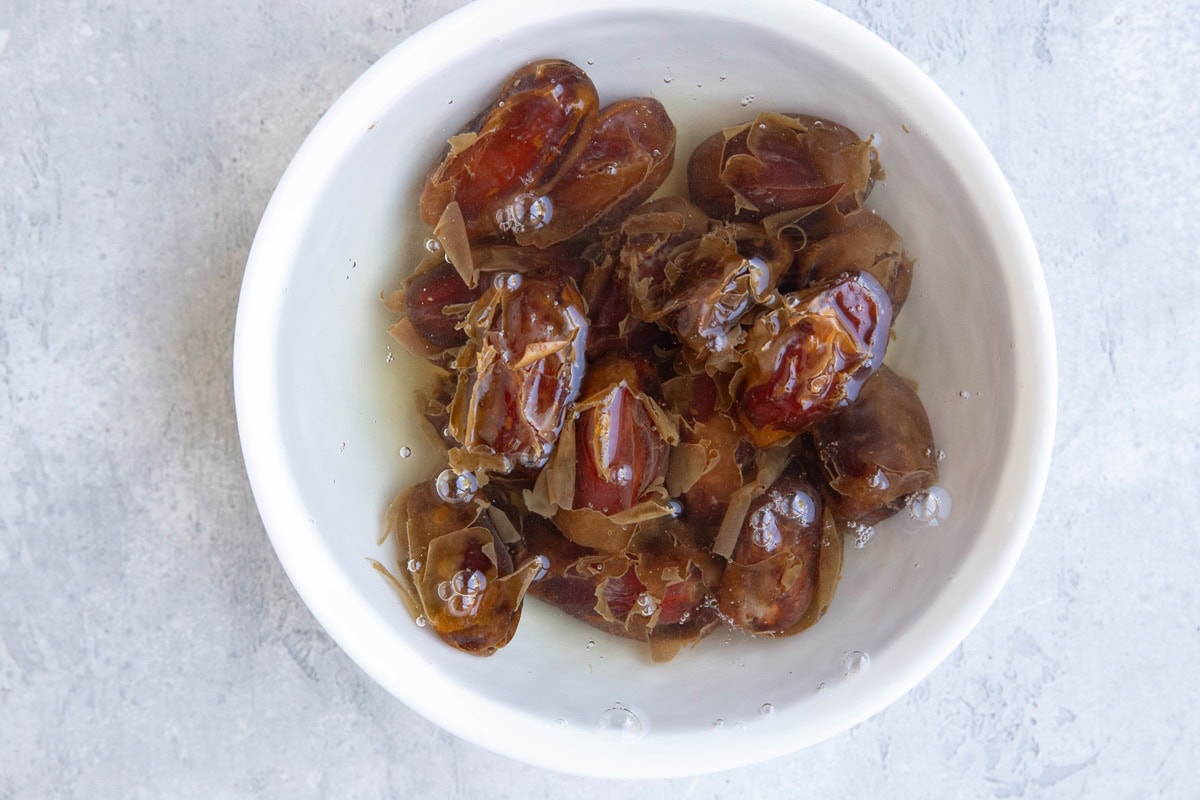 Bowl of water with pitted medjool dates soaking.