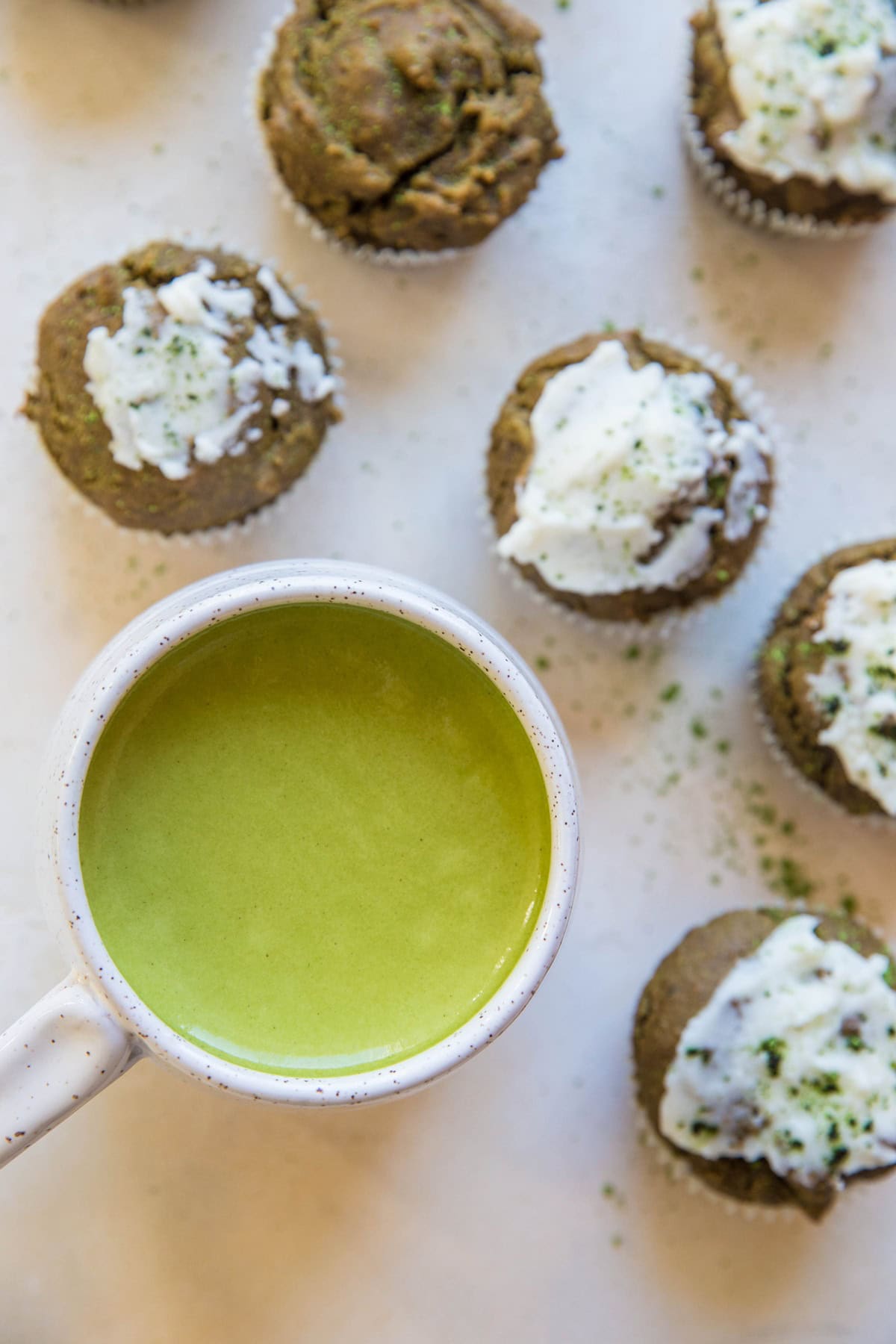 Mug of matcha next to matcha muffins