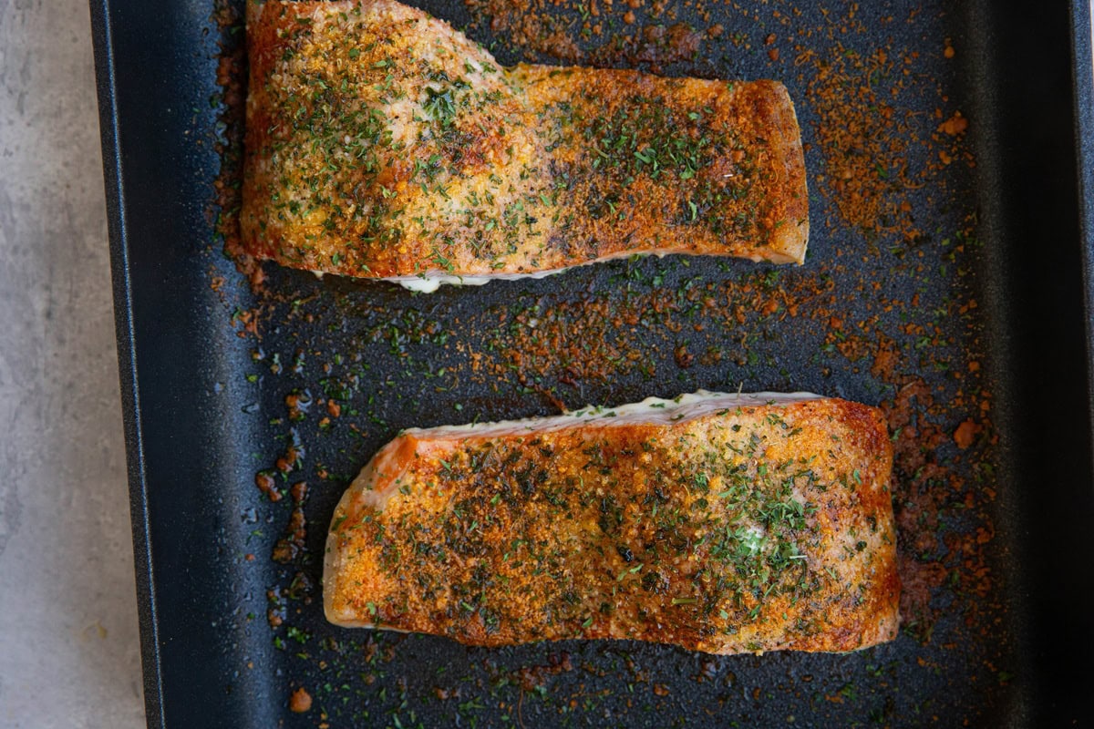parmesan crusted salmon filets in a baking dish, fresh out of the oven.