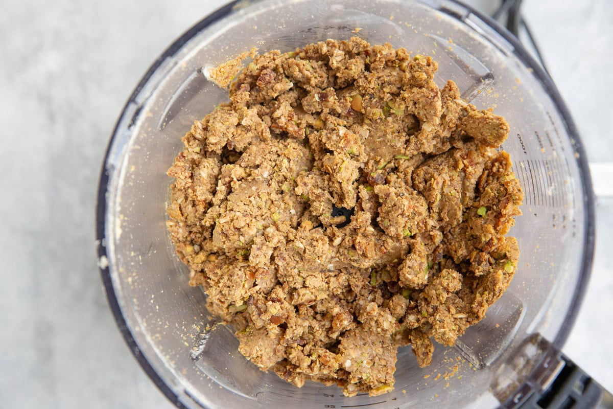 Food processor full of pistachio protein ball ingredients.