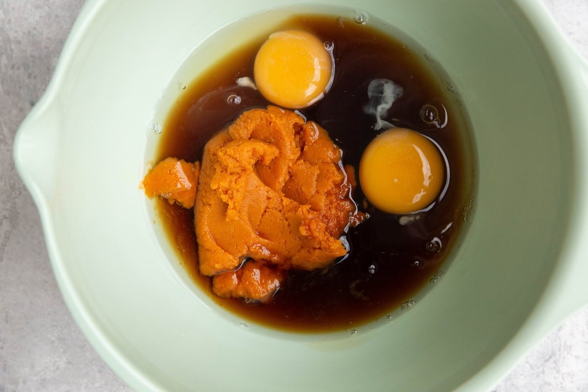 Pumpkin puree, eggs, oil, and pure maple syrup in a mixing bowl.