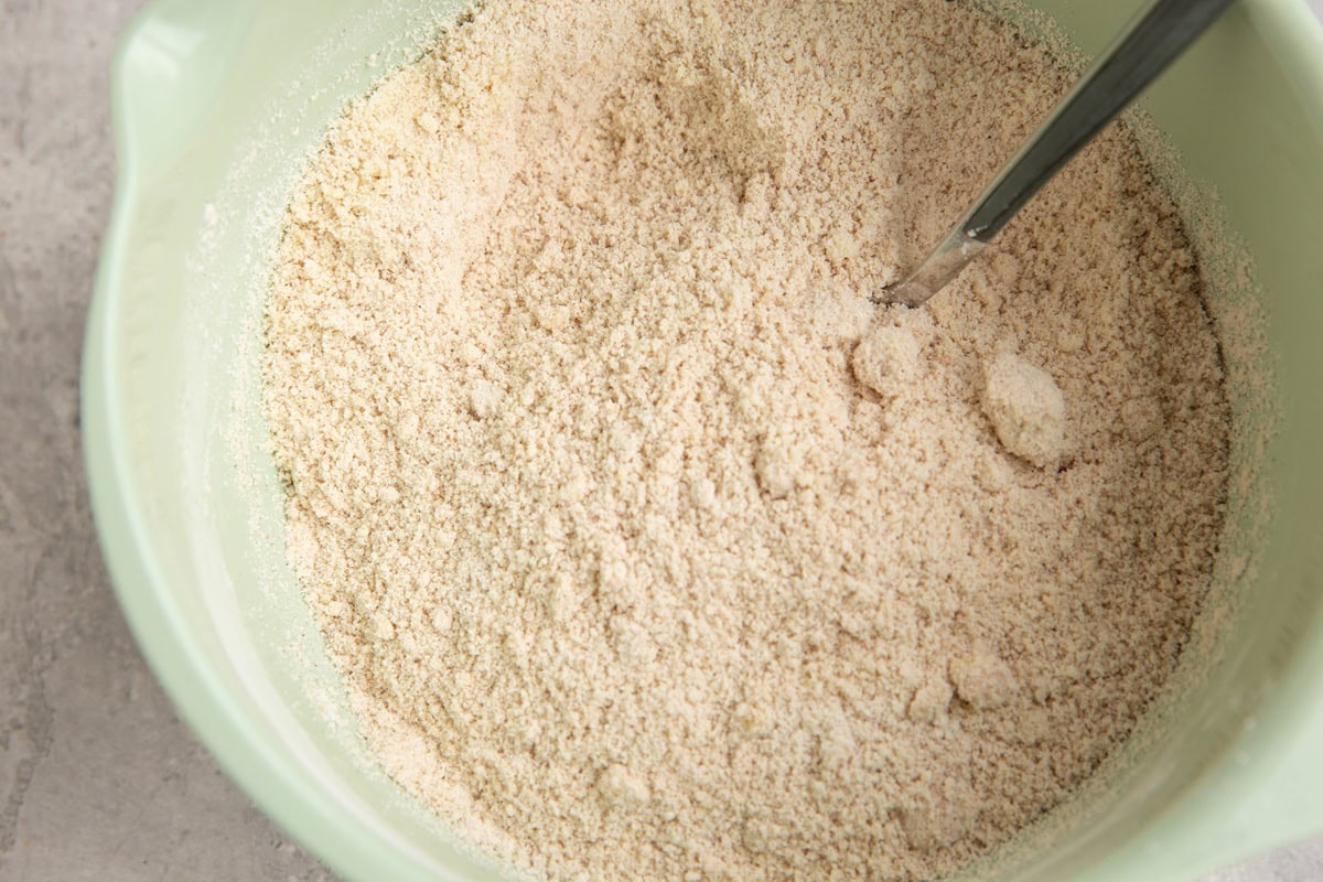 Almond flour, tapioca flour, baking powder, pumpkin spice and salt mixed up in a mixing bowl.