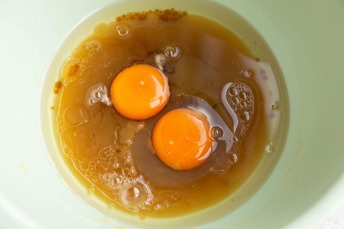 Mixing bowl with apple cider, eggs, and pure maple syrup, ready to be mixed together.