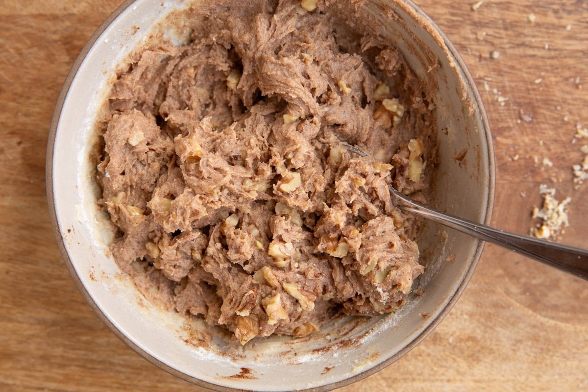Cobbler topping mixture in a medium sized bowl all mixed up with a spoon.