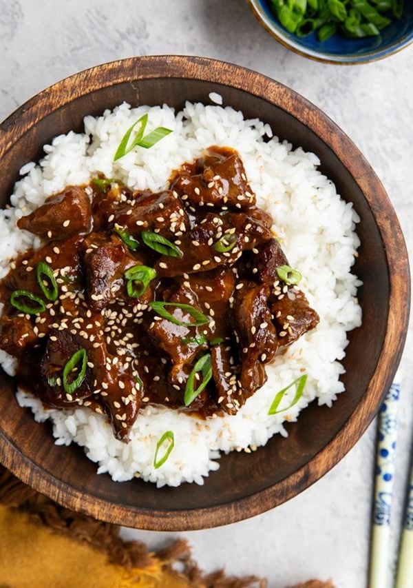 mongolian beef and rice in a wooden bowl.