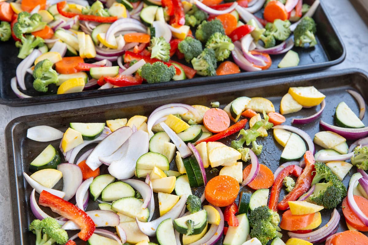 Baking sheets with vegetables spread over them to make roasted vegetables.