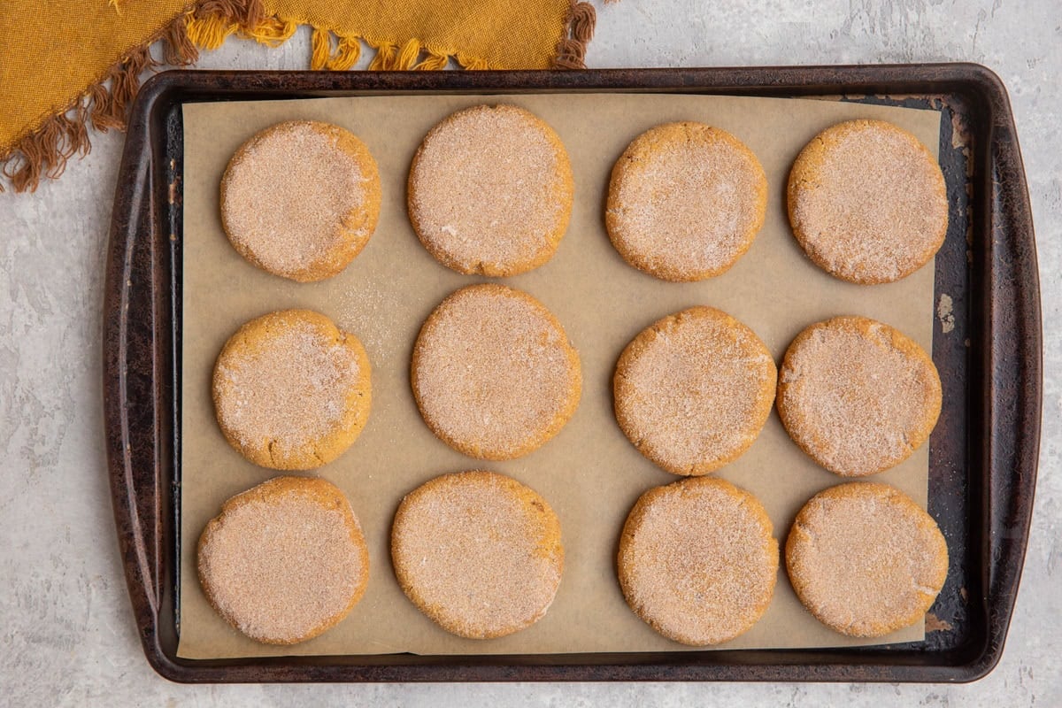 Pumpkin snickerdoodle cookies on a baking sheet, fresh out of the oven.