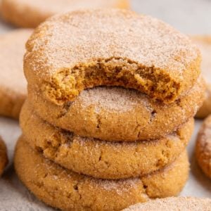 Stack of pumpkin snickerdoodles with more snickerdoodles all around.