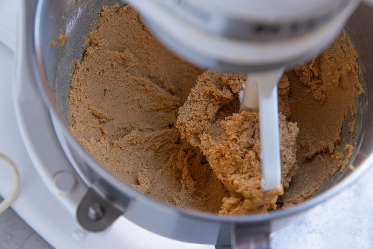 Pumpkin snickerdoodle cookie dough in a stand mixer.