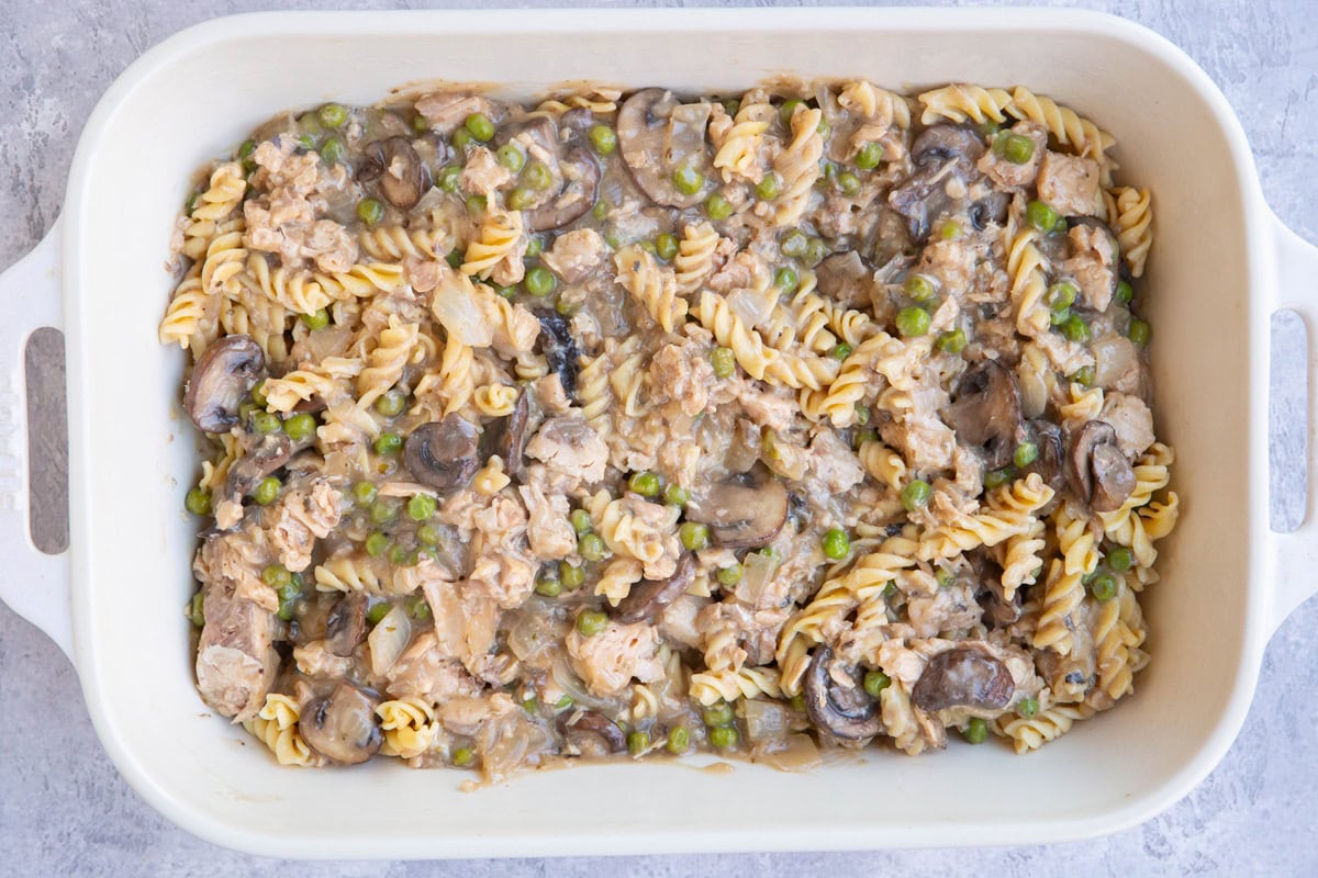 Casserole dish with sauce and noodles mixed up to make salmon casserole.