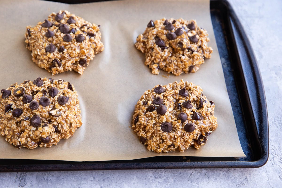 Baking sheet with tahini cookie dough on top, formed into cookie shapes.