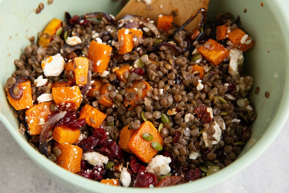 Mixing bowl with butternut squash lentil salad all mixed up.