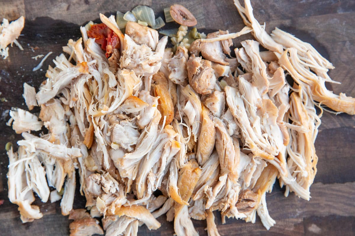 Shredded chicken on a cutting board.