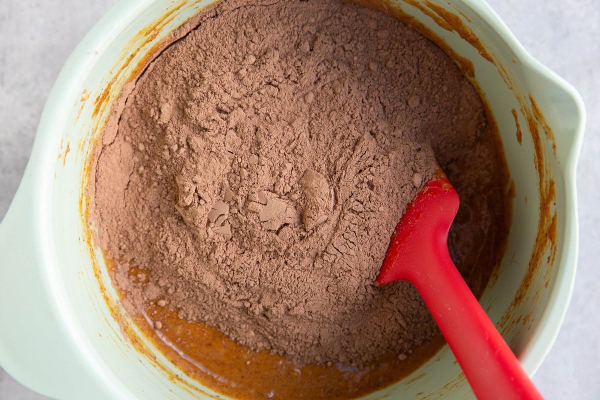 Mixing bowl with cocoa powder and the rest of the dry ingredients on top of the wet ingredients.