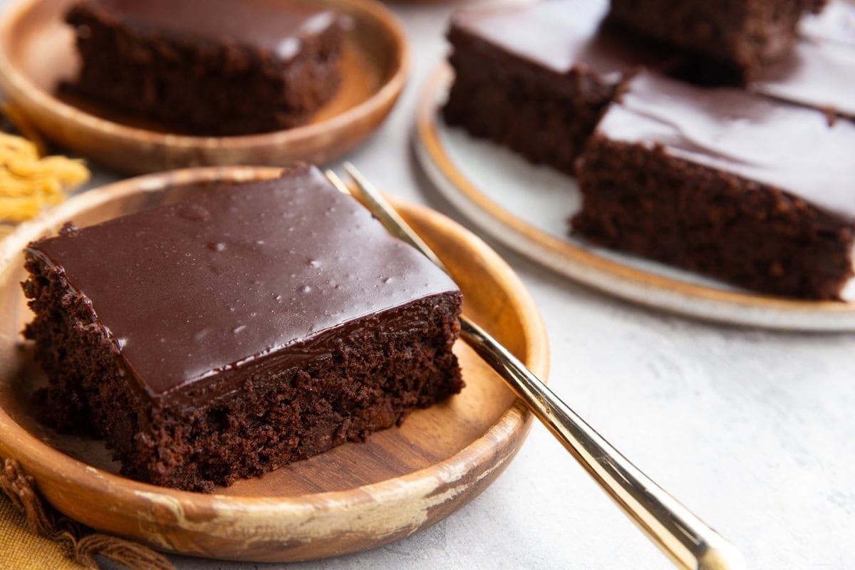 Plates of slices of pumpkin chocolate cake with a gold fork, ready to serve.