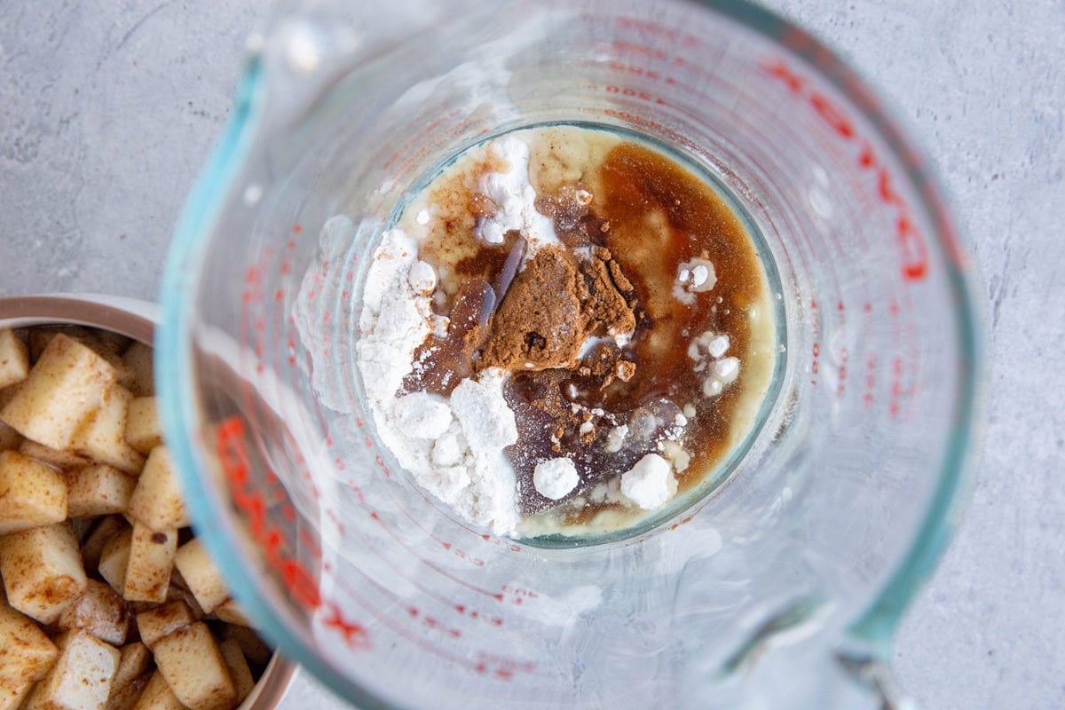 Measuring cup with flour, cinnamon, avocado oil and pure maple syrup, ready to be mixed up.