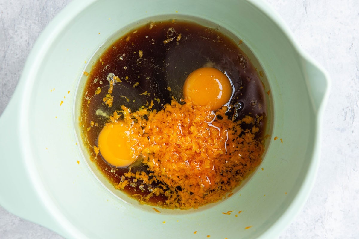 Wet ingredients for cranberry orange scones in a large mixing bowl, ready to be mixed together.