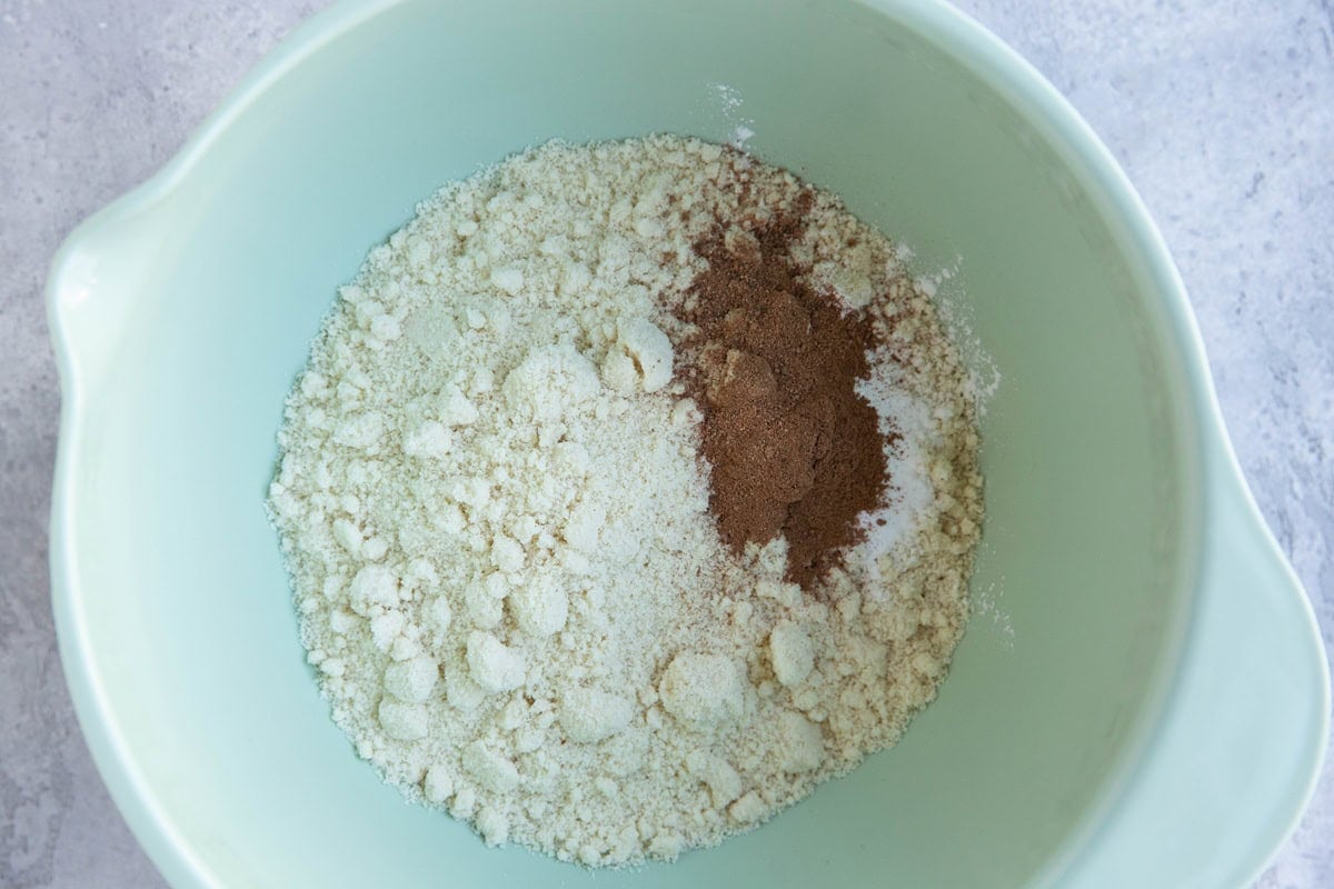 Mixing bowl full of almond flour, cinnamon, nutmeg, and salt for the dry ingredients for gingerbread cookies.