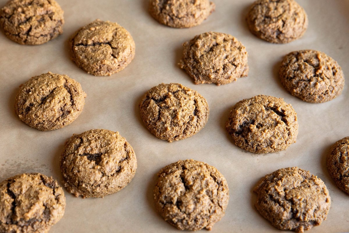ginger molasses cookies on a baking sheet, fresh out of the oven.