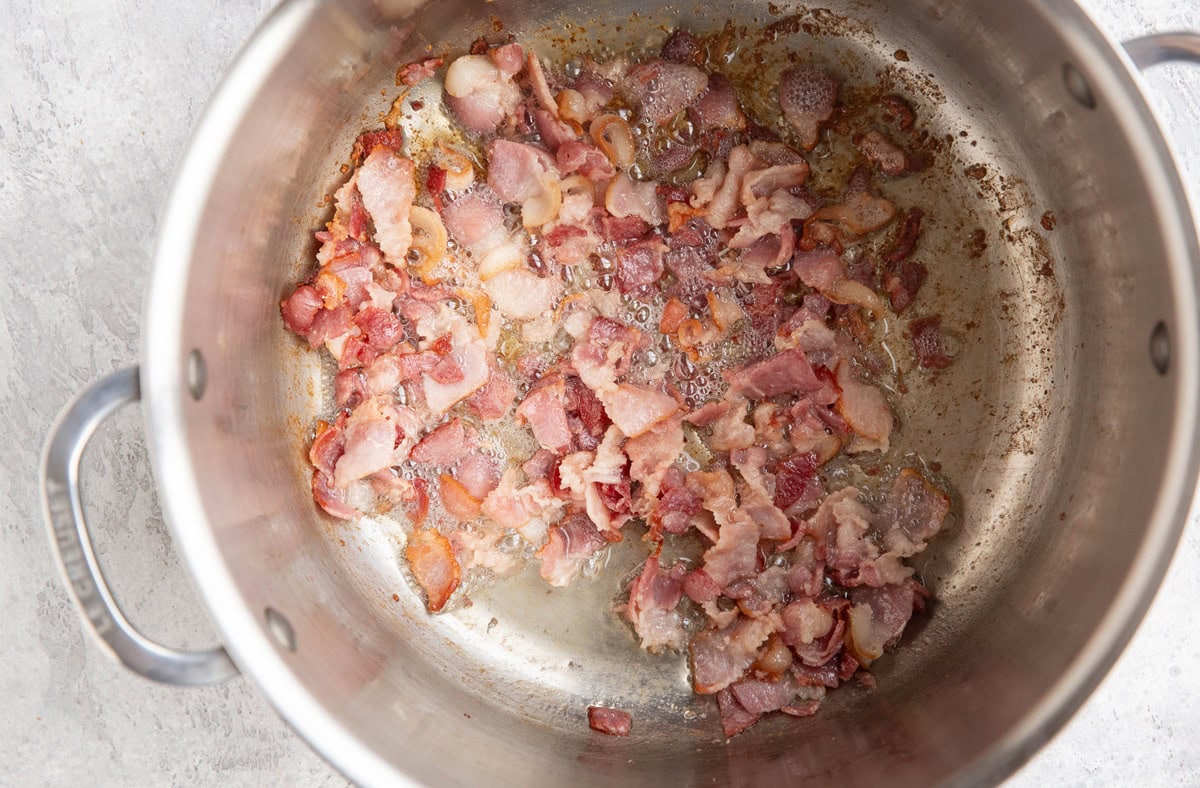 Pot of chopped bacon frying in its own grease.