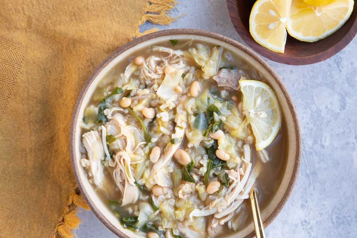 Large bowl of chicken soup with spinach, white beans