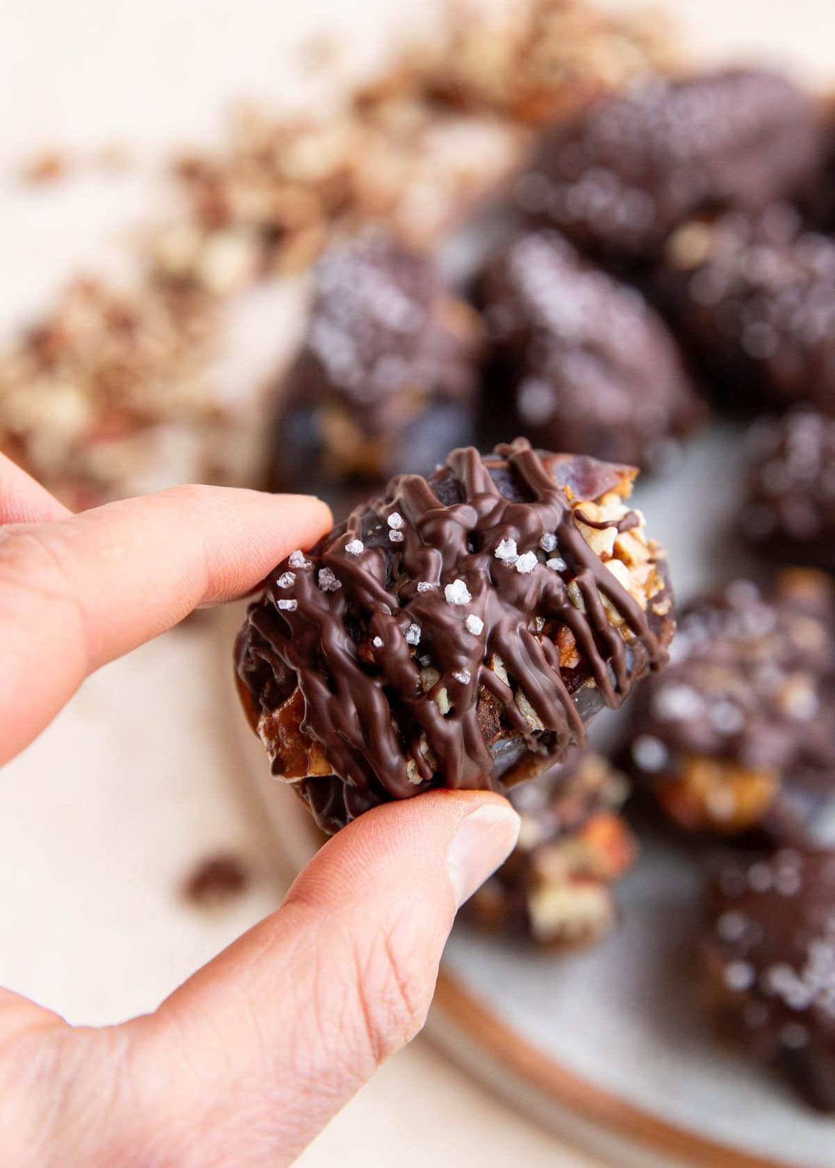 Hand holding a date snickers, ready to take a bite.