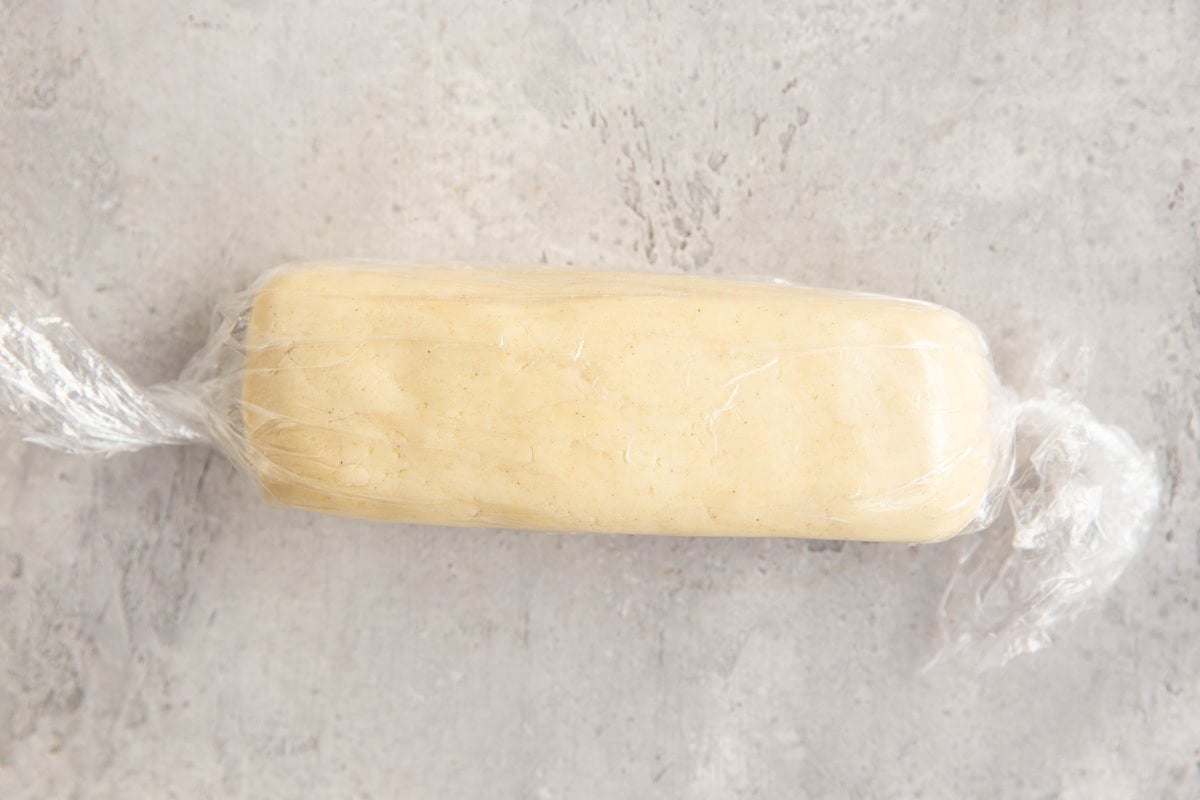 Log of cookie dough wrapped in plastic wrap, ready to be frozen or made into shortbread cookies.