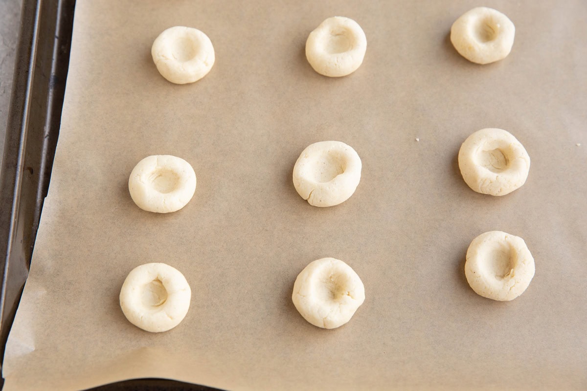 Cookie dough balls with a thumbprint pressed in to make an indentation to put jam.
