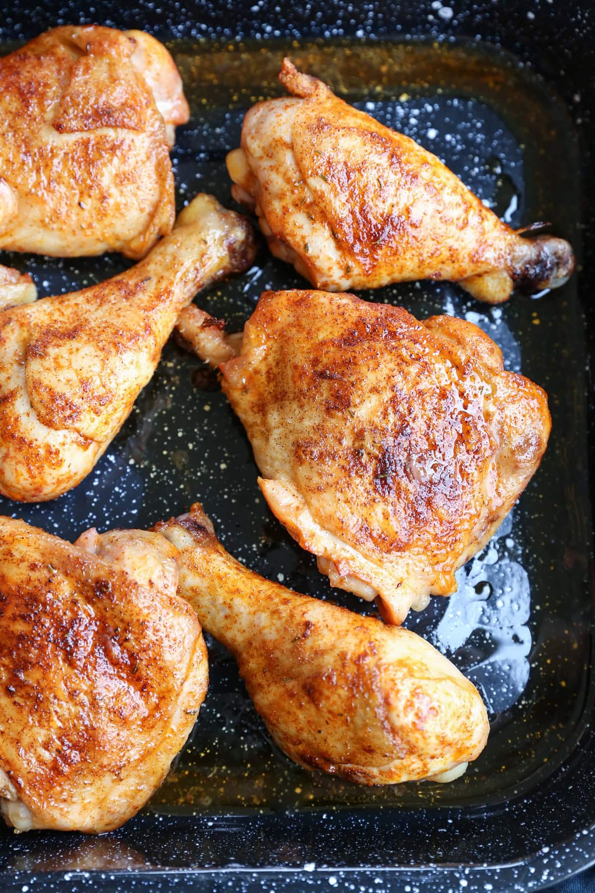 Large baking dish with crispy bone-in chicken pieces coated with a dry rub, and fresh out of the oven.