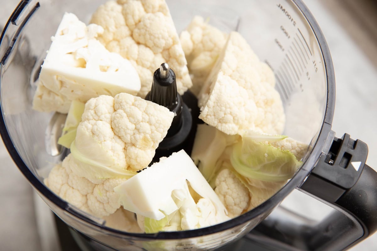 Food processor full of cauliflower florets.