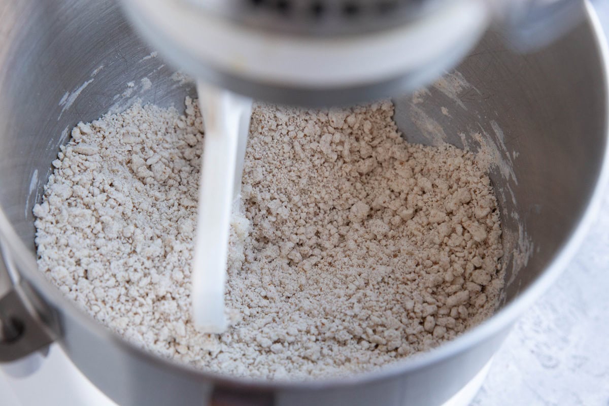 Stand mixer full of ingredients for yogurt bagels, in the process of mixing.