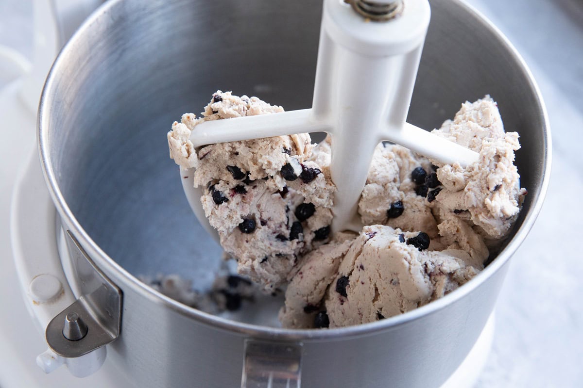 Blueberry bagel dough in a stand mixer with a paddle attachment. Finished making and ready to bake.
