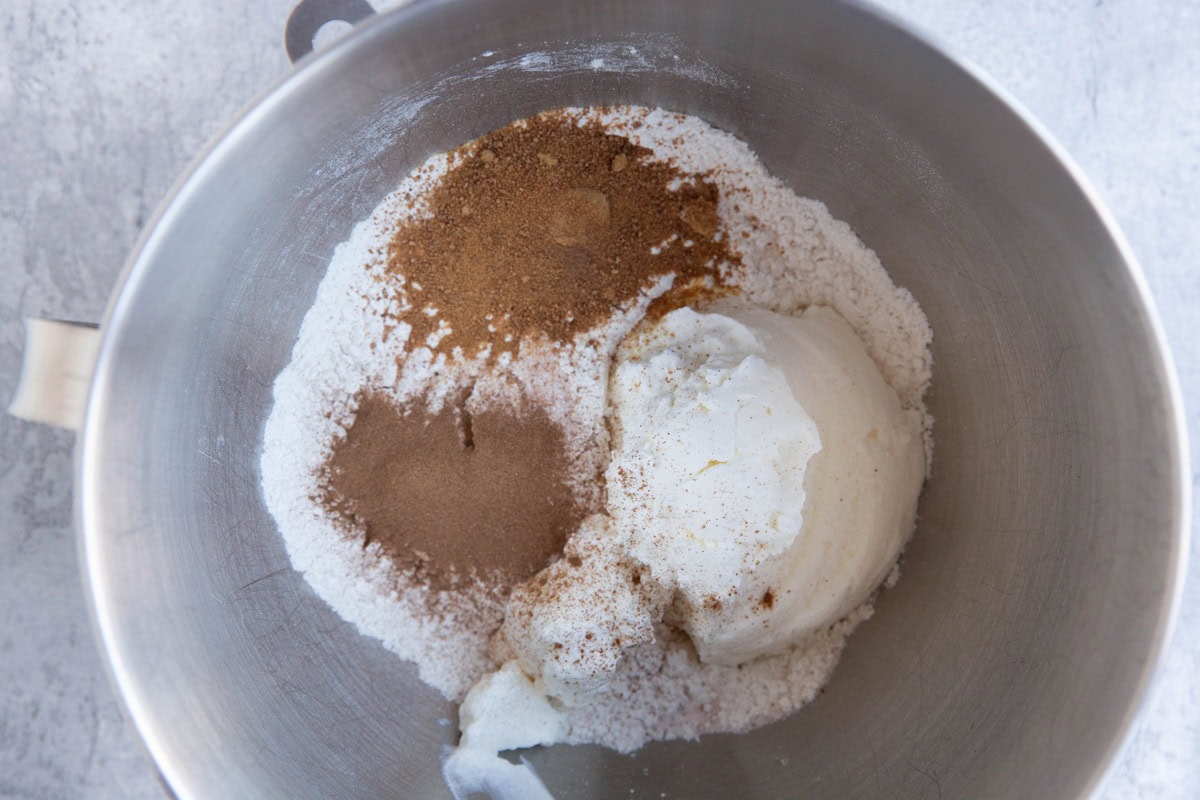 Stand mixer full of flour, cinnamon, sugar, and Greek yogurt to make bagels.