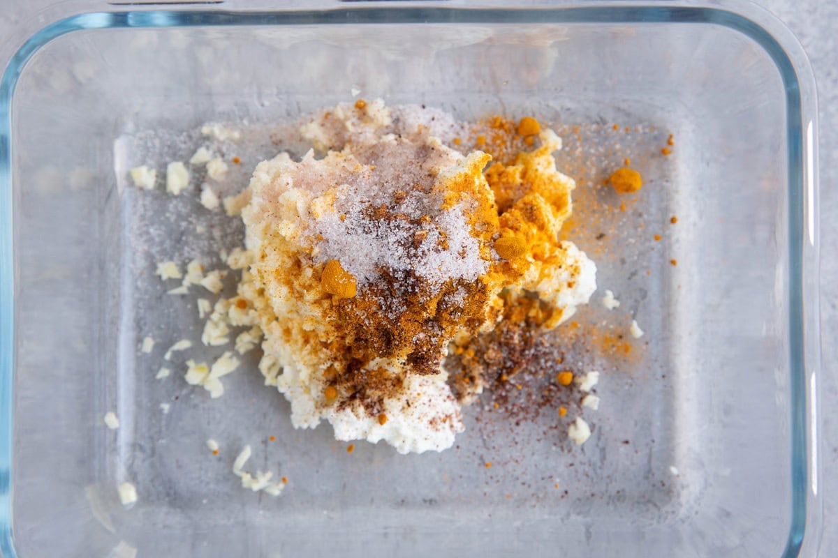Greek yogurt and seasonings in a Tupperware container to make a lamb marinade.