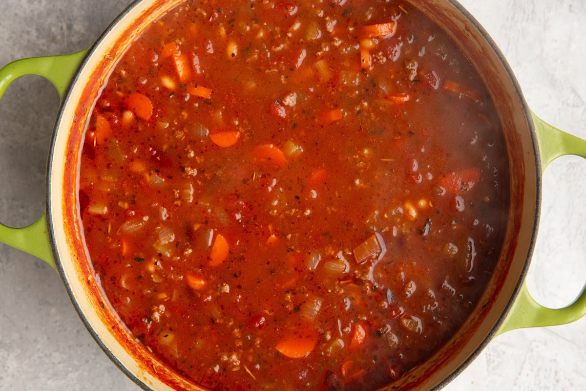 Large soup pot full of tomato based soup. Ground beef, veggies and tomato broth.
