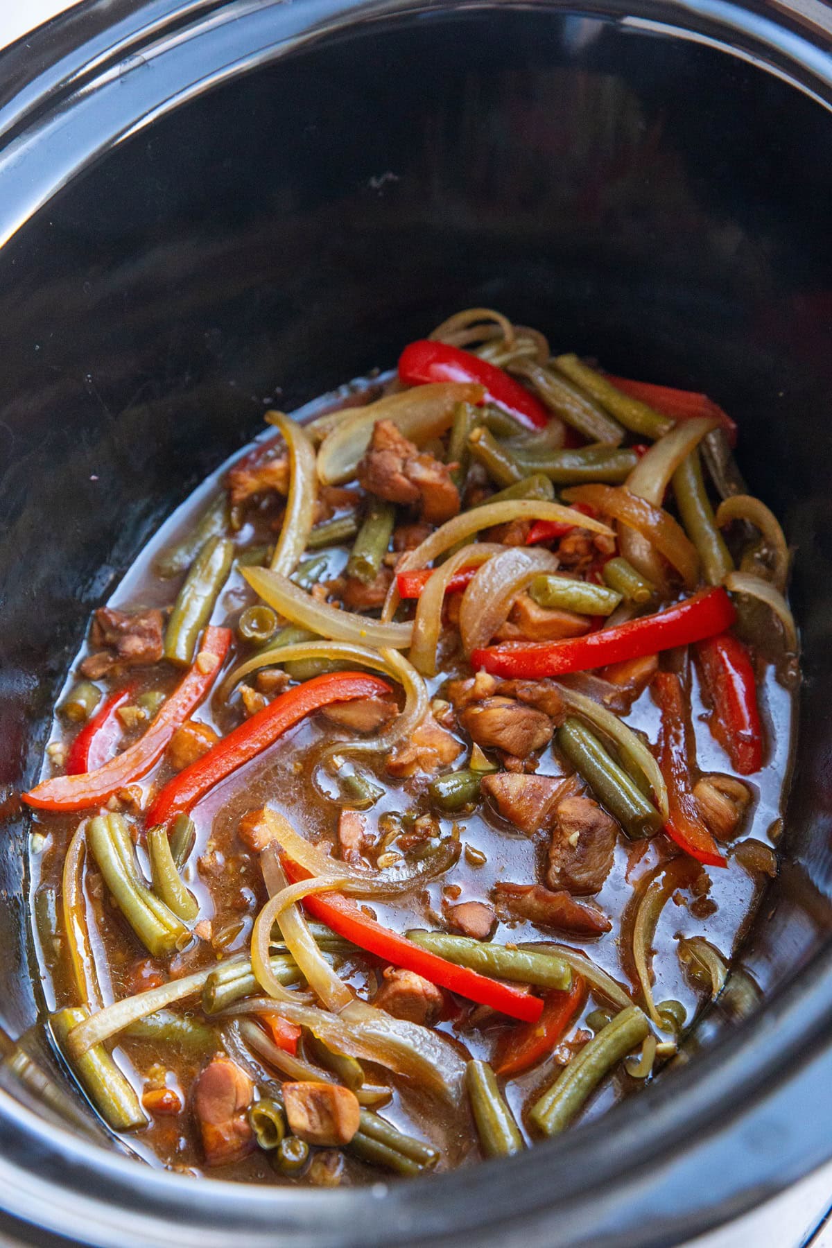 Slow cooker full of chicken teriyaki ingredients, freshly cooked and ready to serve.