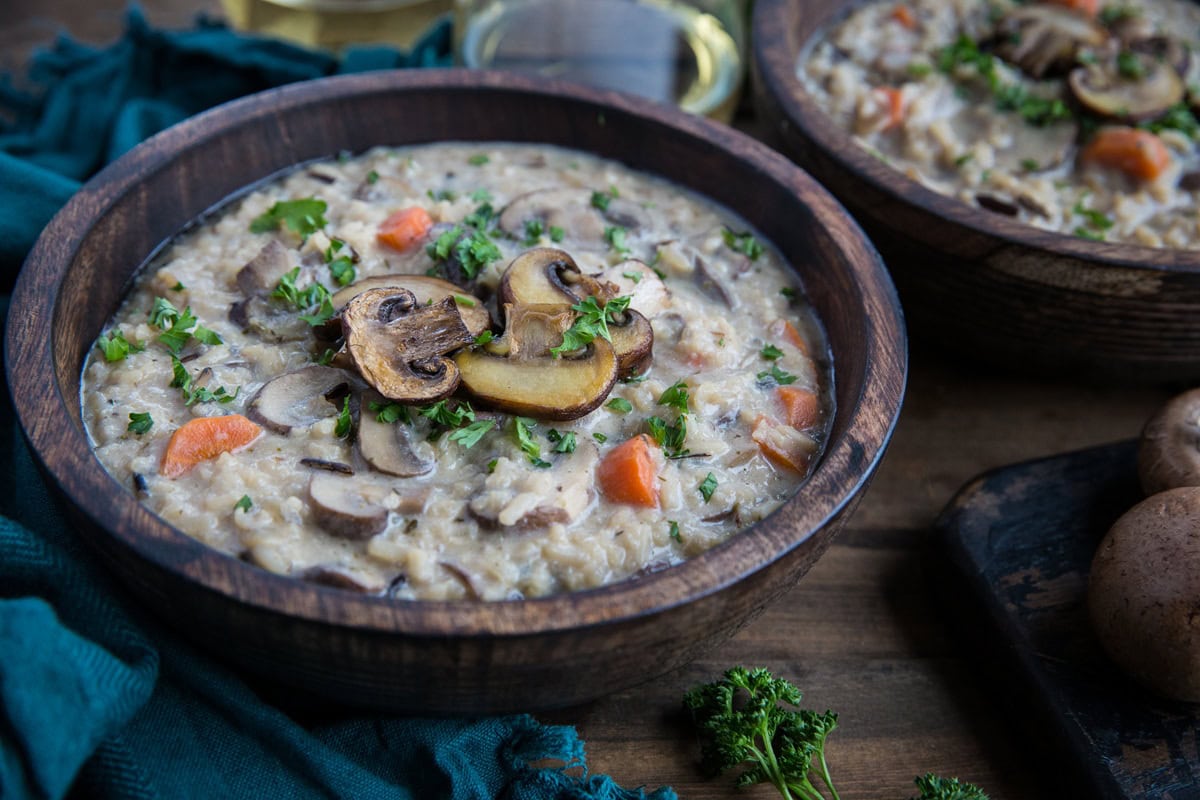 Two wooden bowls full of creamy mushroom soup.