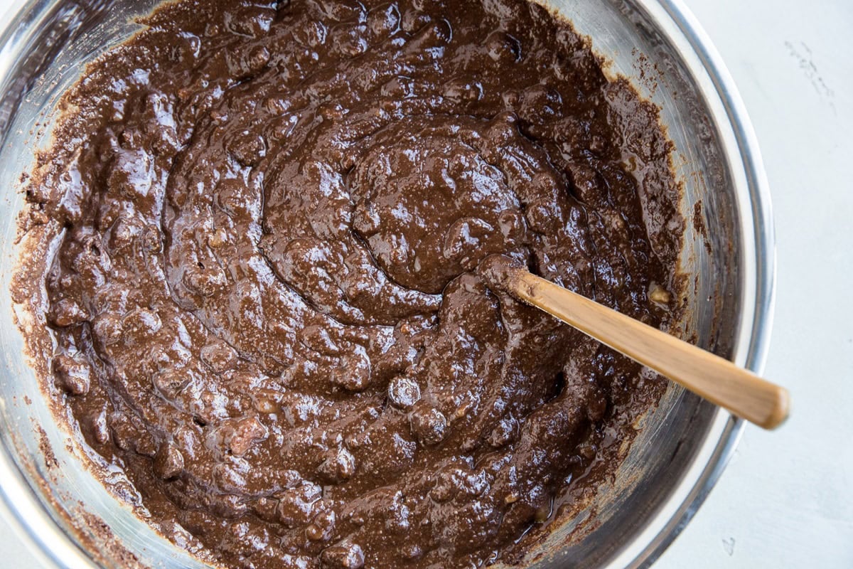 Mixing bowl full of chocolate cake batter mixed up with a fork.