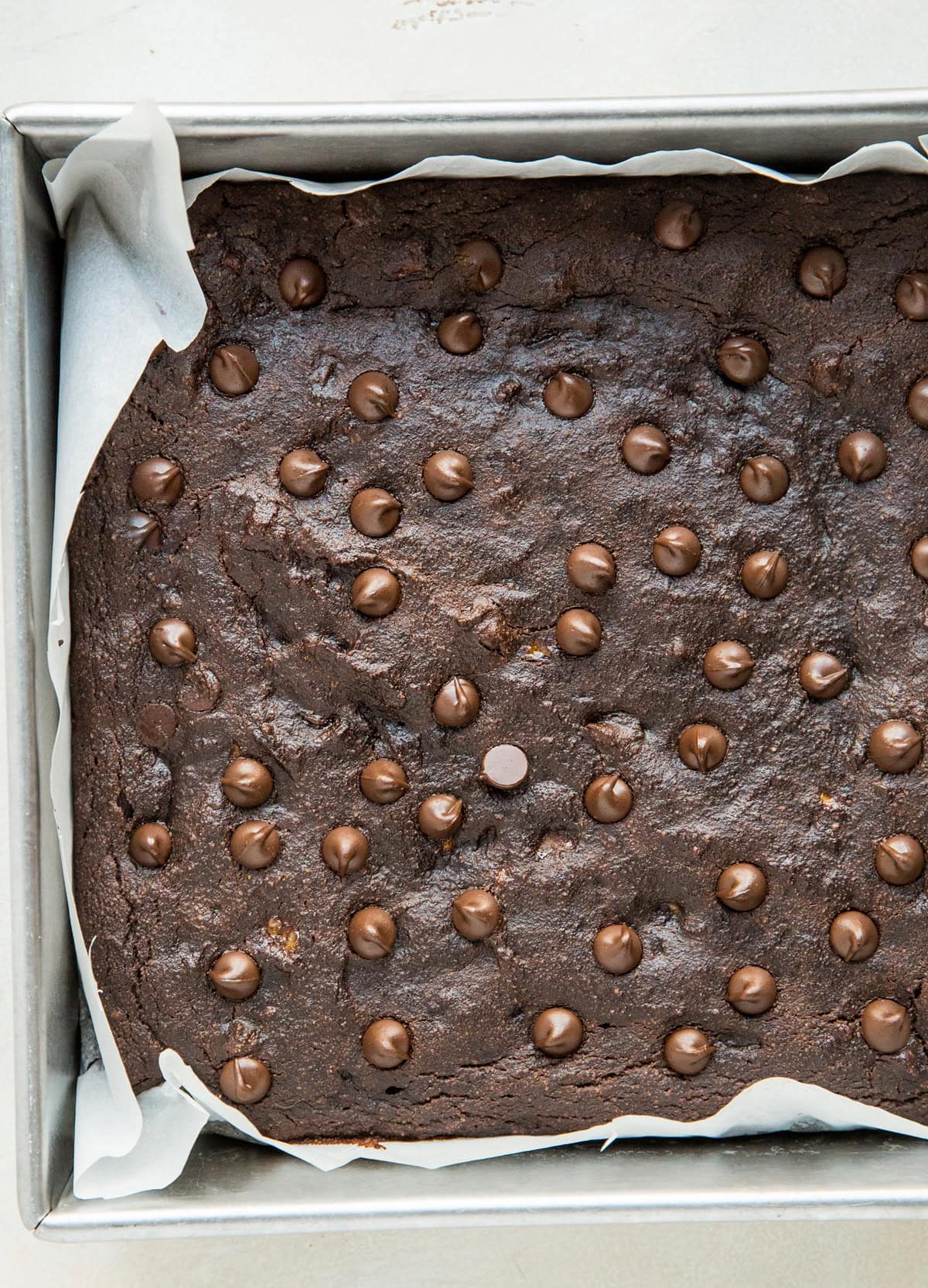 Chocolate banana cake in a baking pan sprinkled with chocolate chips, fresh out of the oven.