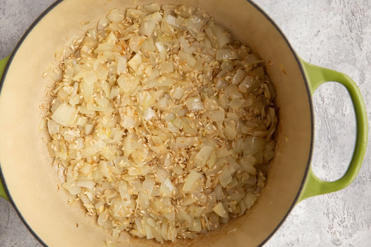 Pot of rice, garlic, and brown rice sauteeing.
