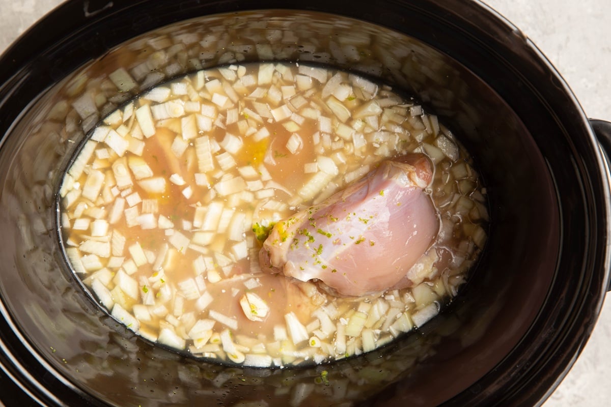 Broth, chicken, onion, ginger, and garlic in a slow cooker.