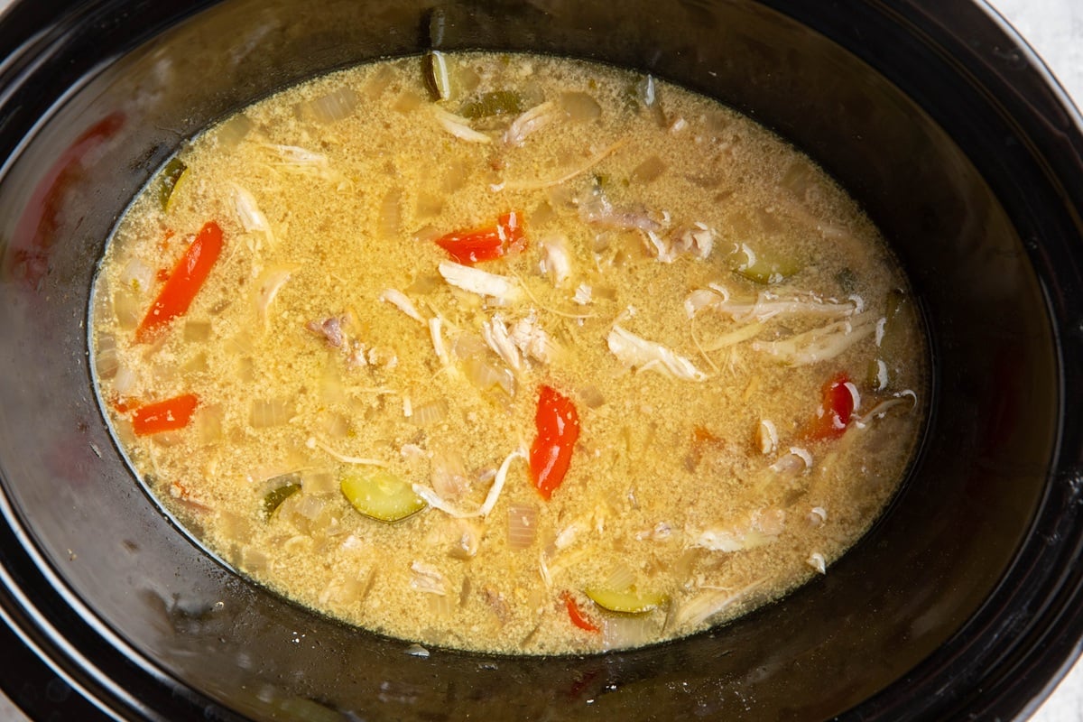 Crock pot filled with chicken coconut soup and vegetables, ready to serve.