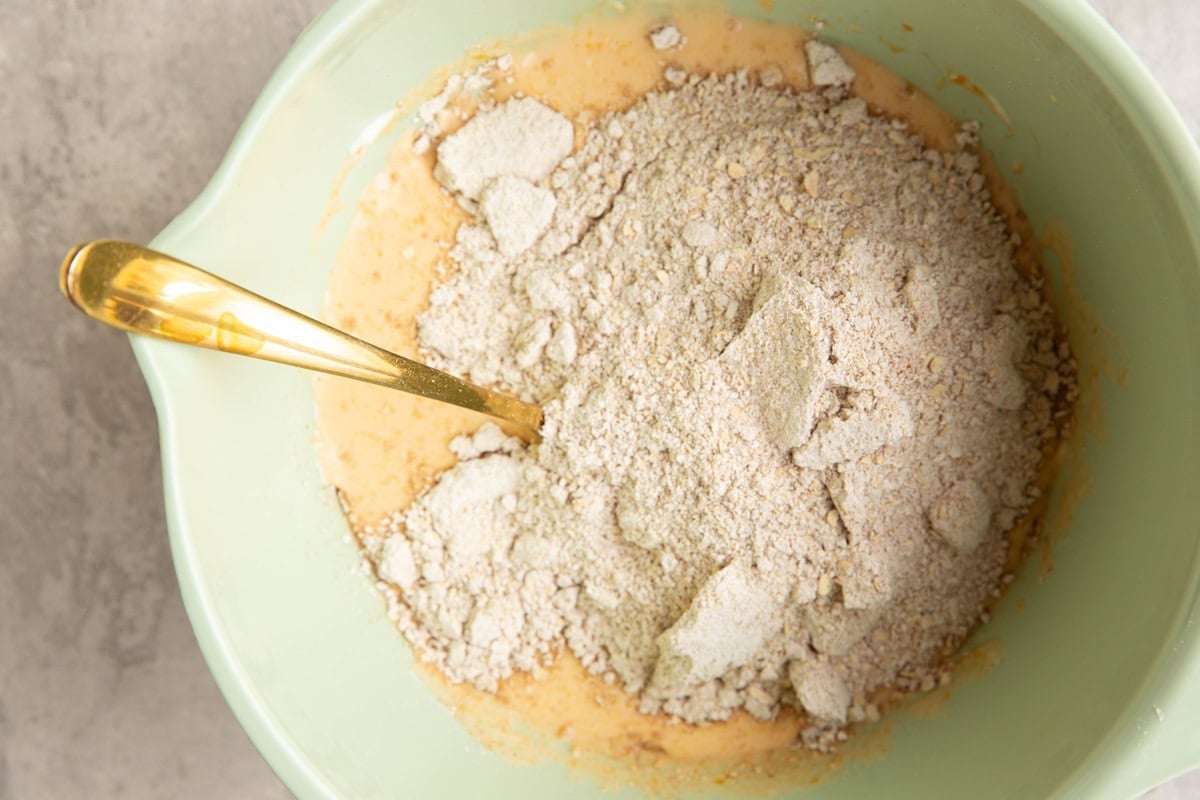 Mixing bowl with wet ingredients at the bottom and dry ingredients on top, ready to be mixed together.