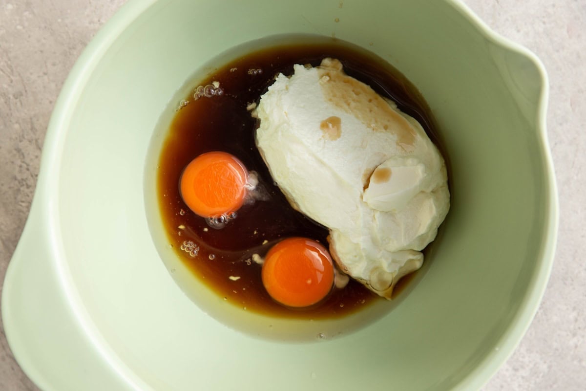 Mixing bowl full of Greek yogurt, eggs, pure maple syrup, and oil.