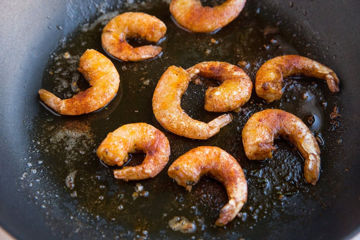 Shrimp sautéing in a small skillet in a single layer.