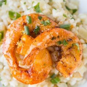 Lemon Garlic shrimp with sear marks on top of risotto sprinkled with green onions.