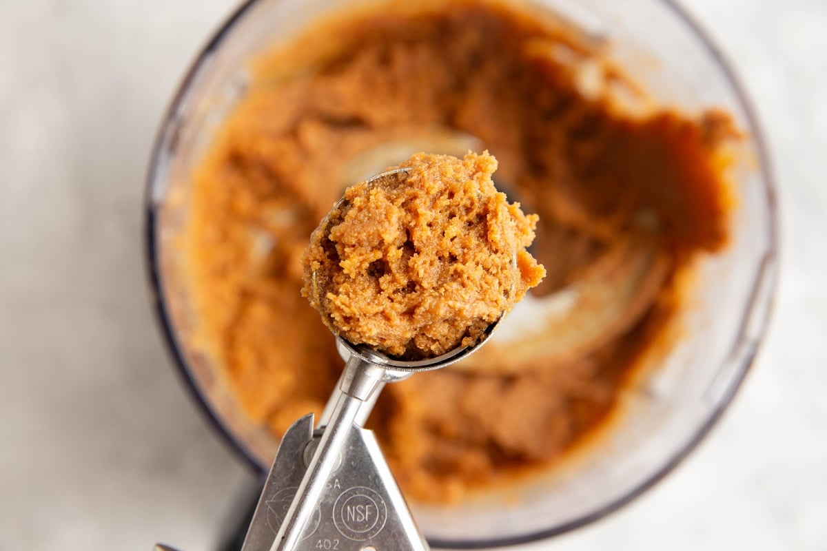 Cookie scoop with peanut butter cookie dough scooped inside, ready to put on a baking sheet.