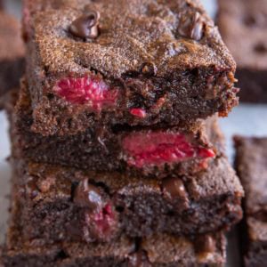 Stack of four raspberry brownies, exposing their fudgy middle. Ready to enjoy!