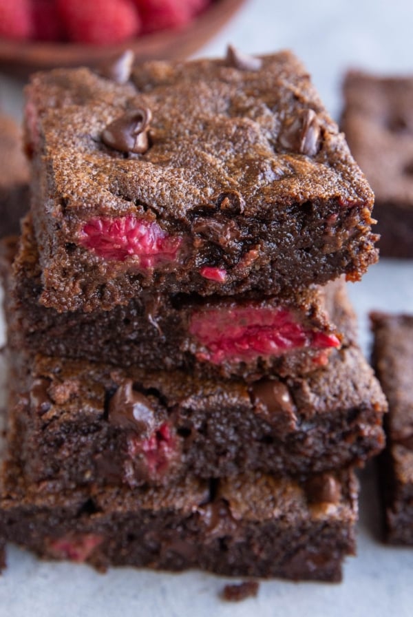 Stack of four raspberry brownies, exposing their fudgy middle. Ready to enjoy!